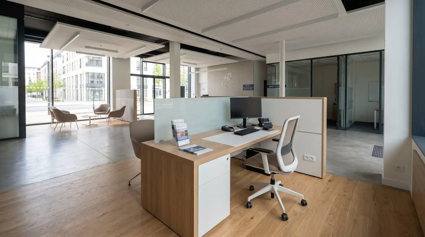 Intérieur d'une agence bancaire française moderne et vide, bureau de consultation avec deux chaises se faisant face, design contemporain épuré, lumière naturelle abondante